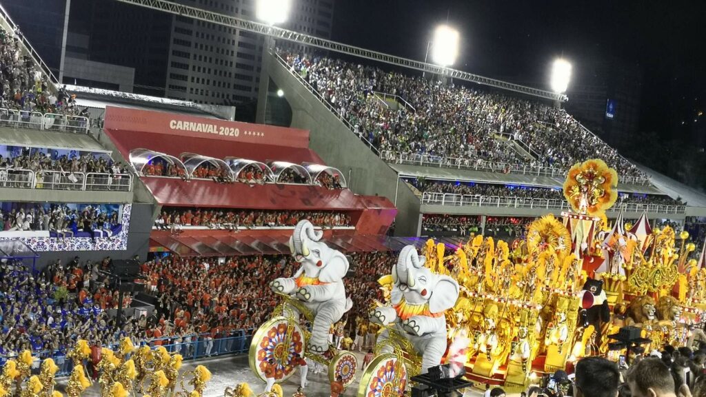 Samba school parade at the Sambadrome during Rio de Janeiro Carnival, with giant elephant floats and dancers in gold costumes